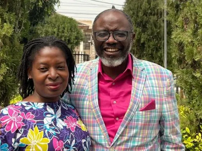 Pastor Bukky and Bola Ajide smiling together outdoors among the trees