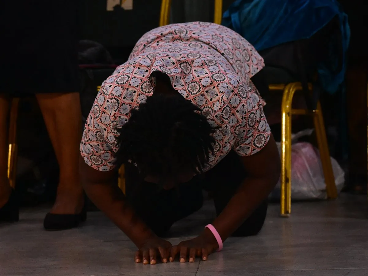A woman kneeling with her face to the floor in prayer