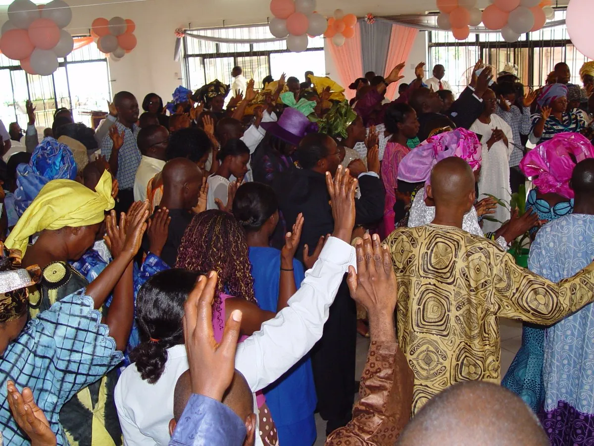A packed hall with hands raised in worship at the 2004 convention