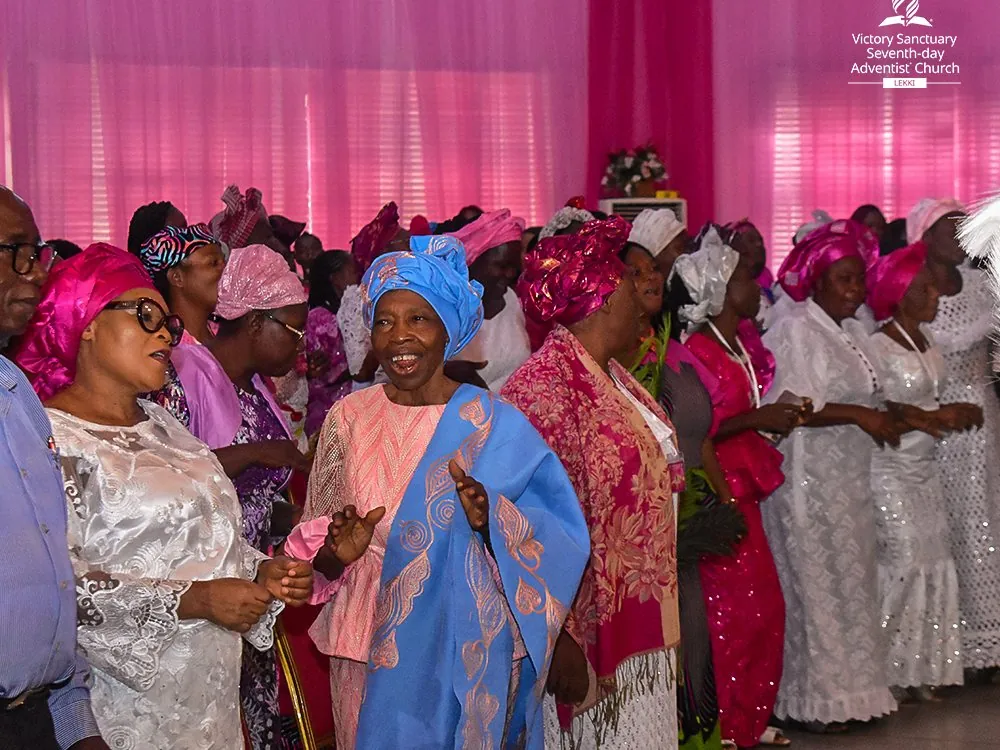Women in pink and white dancing in the aisles at the King’s Daughters Conference