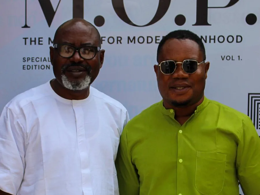 Two men smiling in front of the Men of Purpose conference backdrop