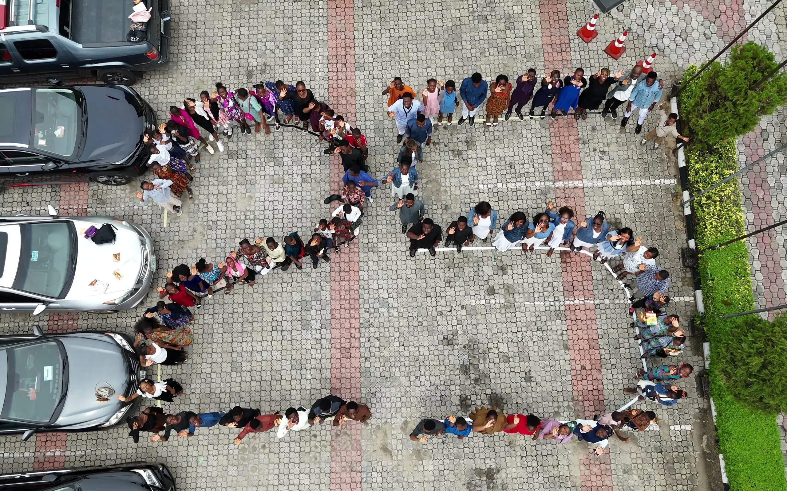 Church members standing together in the shape of the number 25 in the church grounds, seen from above