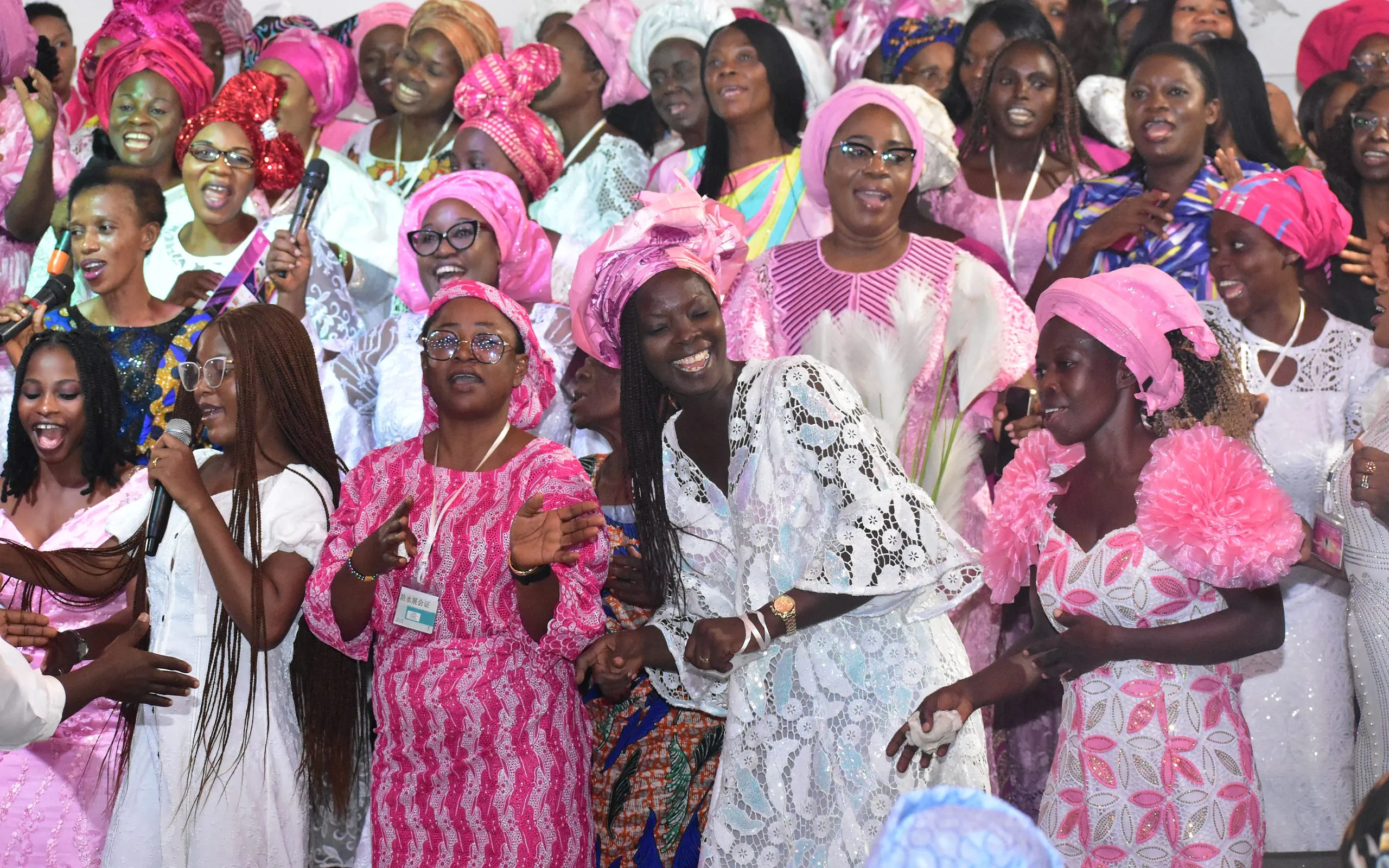Women in pink and white singing together at the King’s Daughters conference
