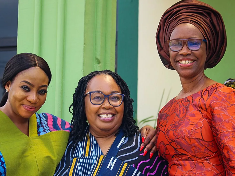 Three women smiling together outside the church