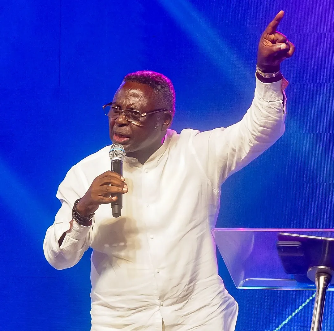 Pastor Matthew Ashimolowo preaching with his hand raised