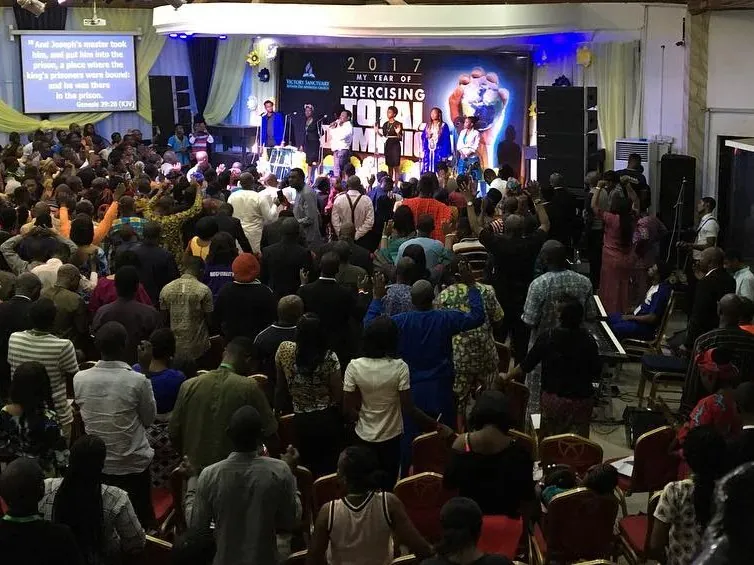 The whole hall standing in worship in front of the Exercising Total Dominion stage