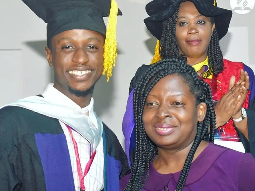 Bible school graduates smiling in their caps and gowns
