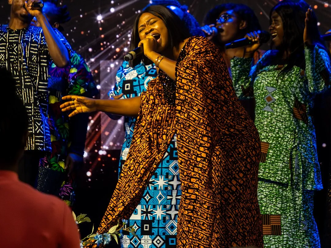 The praise team singing on a stage lit with sparkling lights